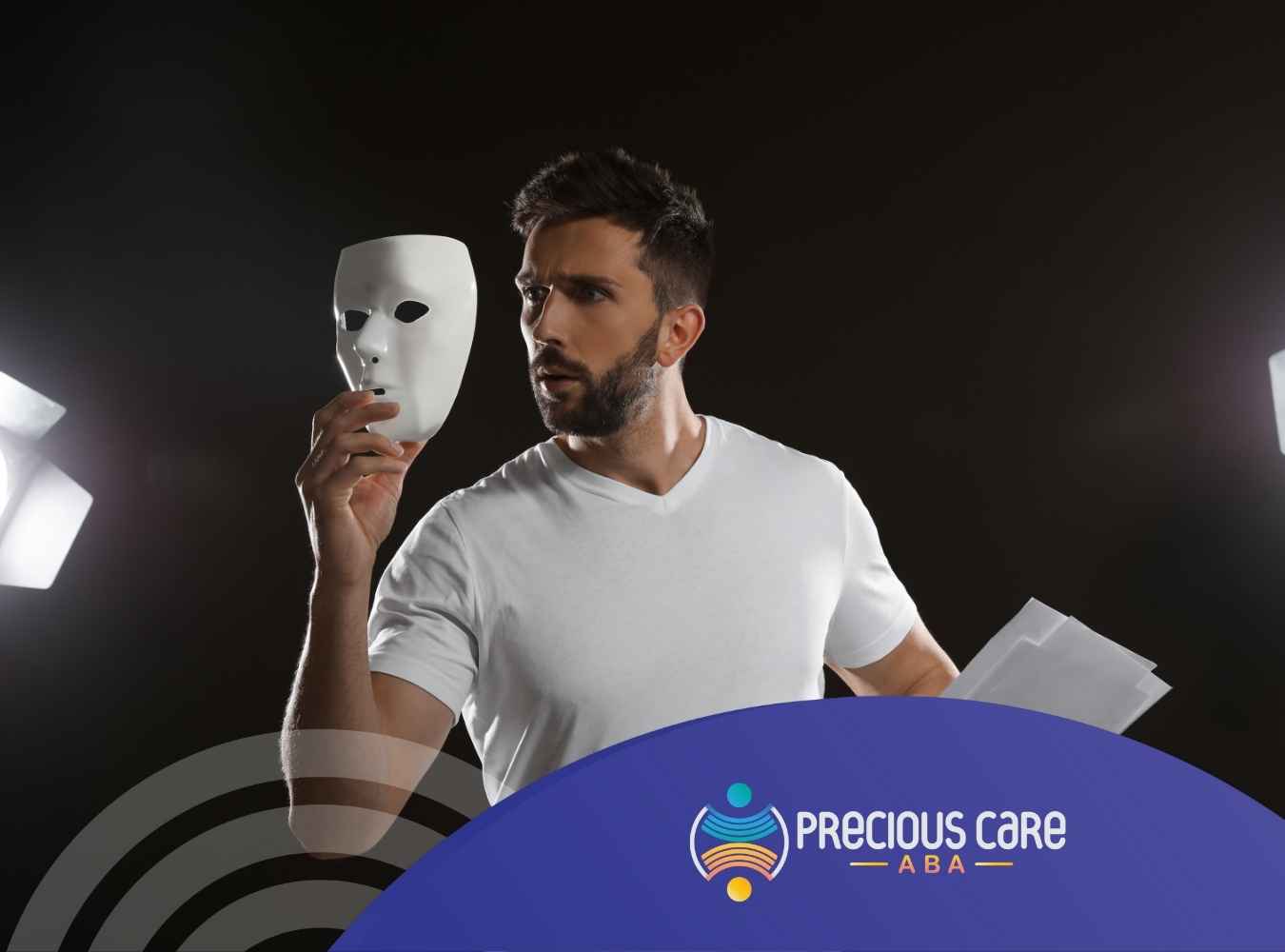 Man in a white shirt holds a white mask and papers, standing between softbox lights, conveying contemplation.