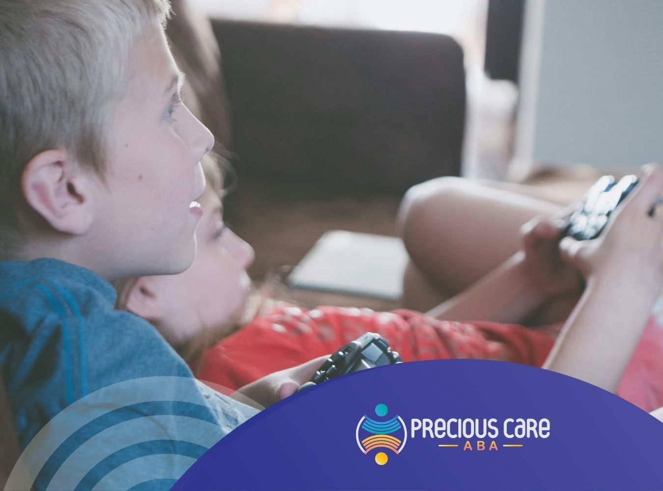 Two autistic children sit on a couch, focused on their video game controllers while playing in NJ.