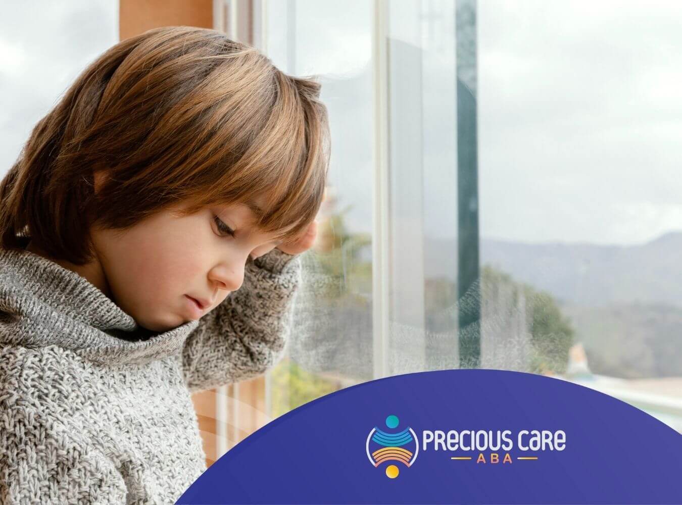 A child with autism is standing near a window during ABA therapy.