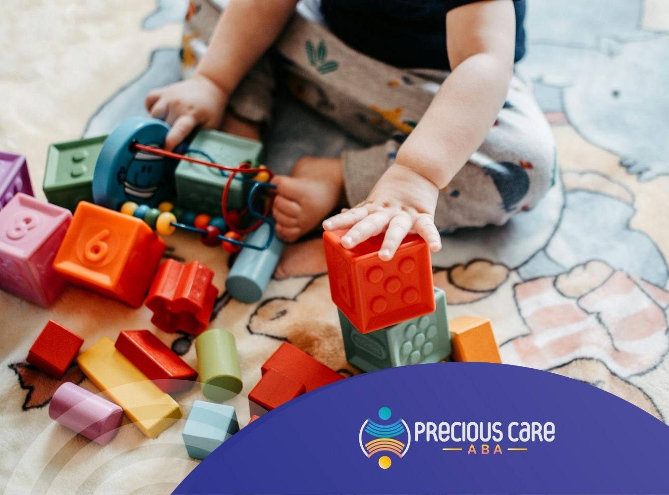 An autistic toddler playing with colorful blocks and toys on a cartoon animal playmat in New Jersey.