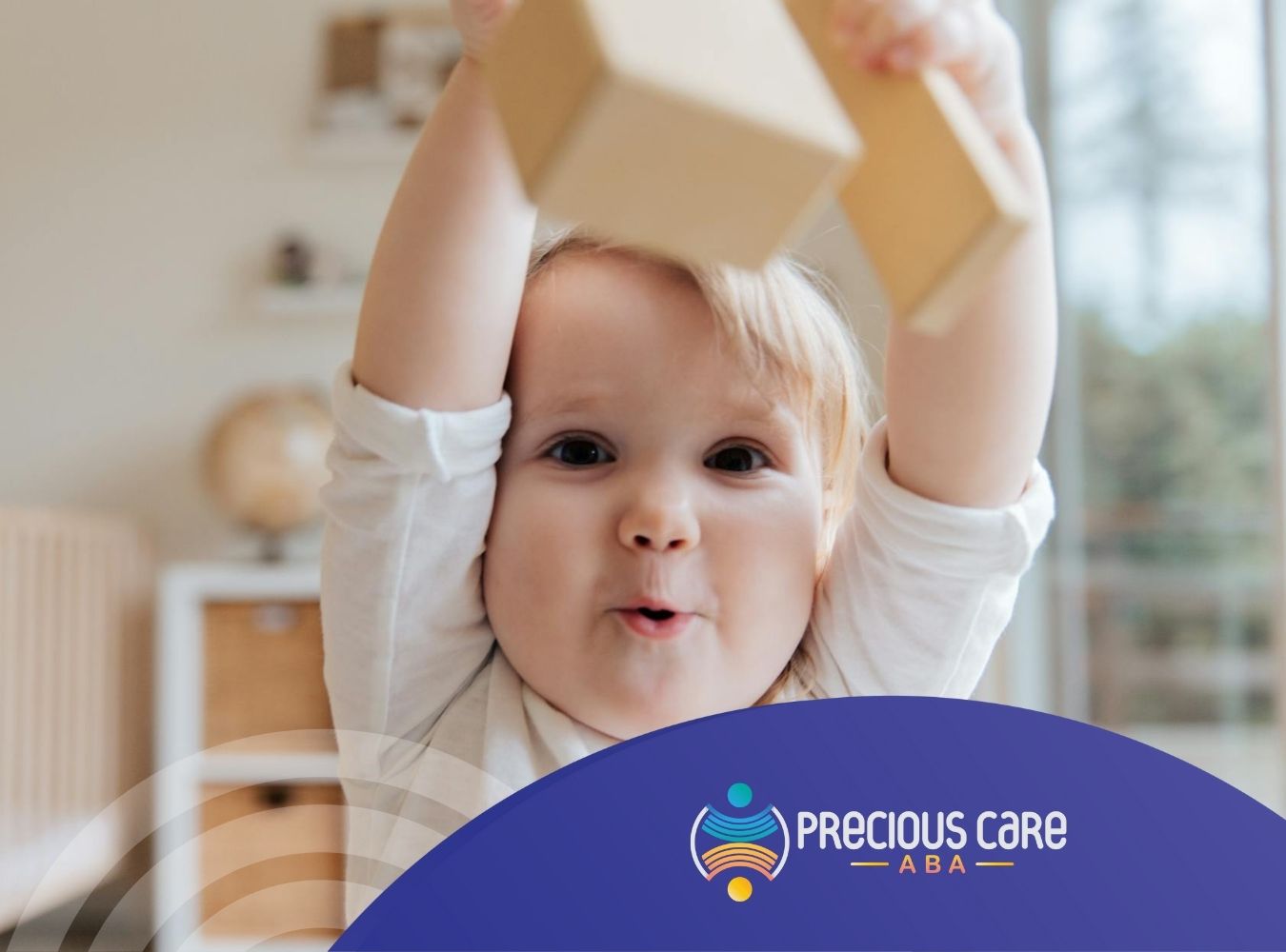 An autistic baby happily lifting wooden blocks in a bright indoor space during in-home ABA therapy in New Jersey.