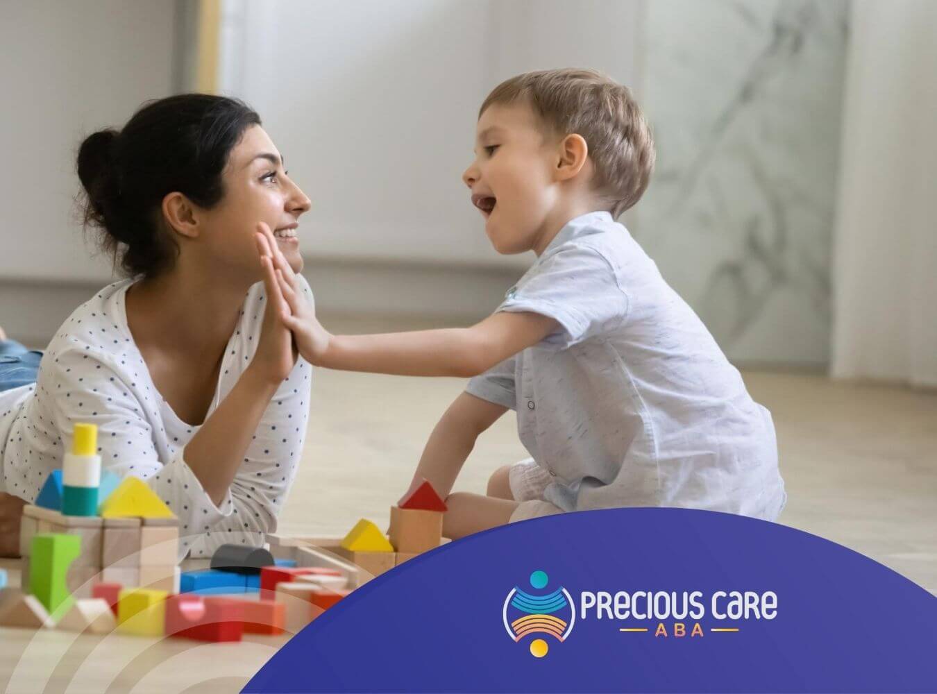 ABA therapist and autistic lying on the floor, interacting and smiling in ABA therapy.