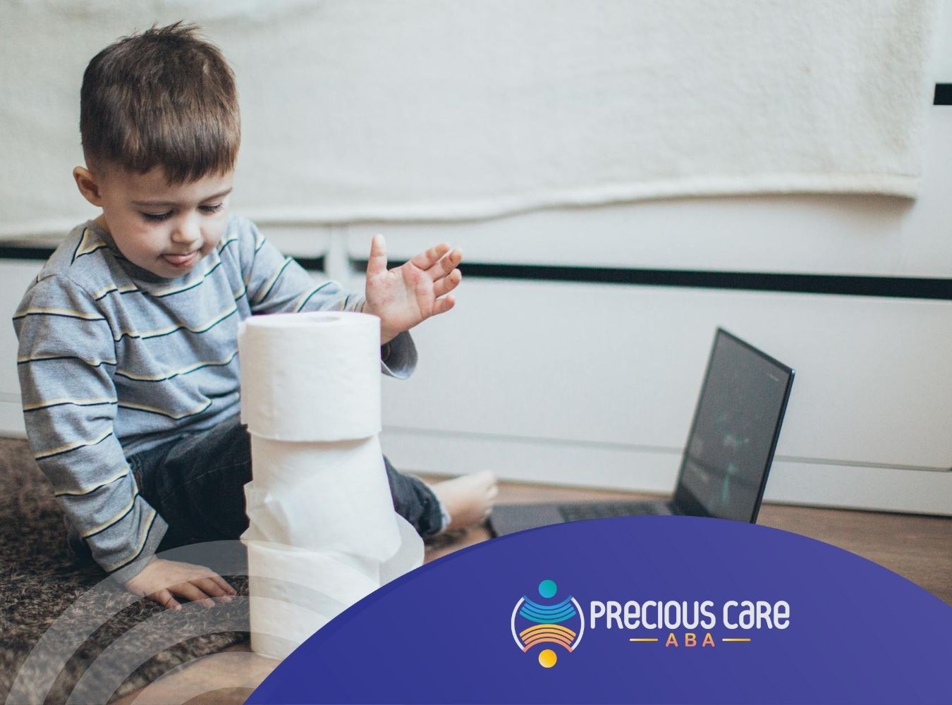 An autistic child stacking toilet paper rolls next to a laptop during in-home ABA therapy session in Maryland.