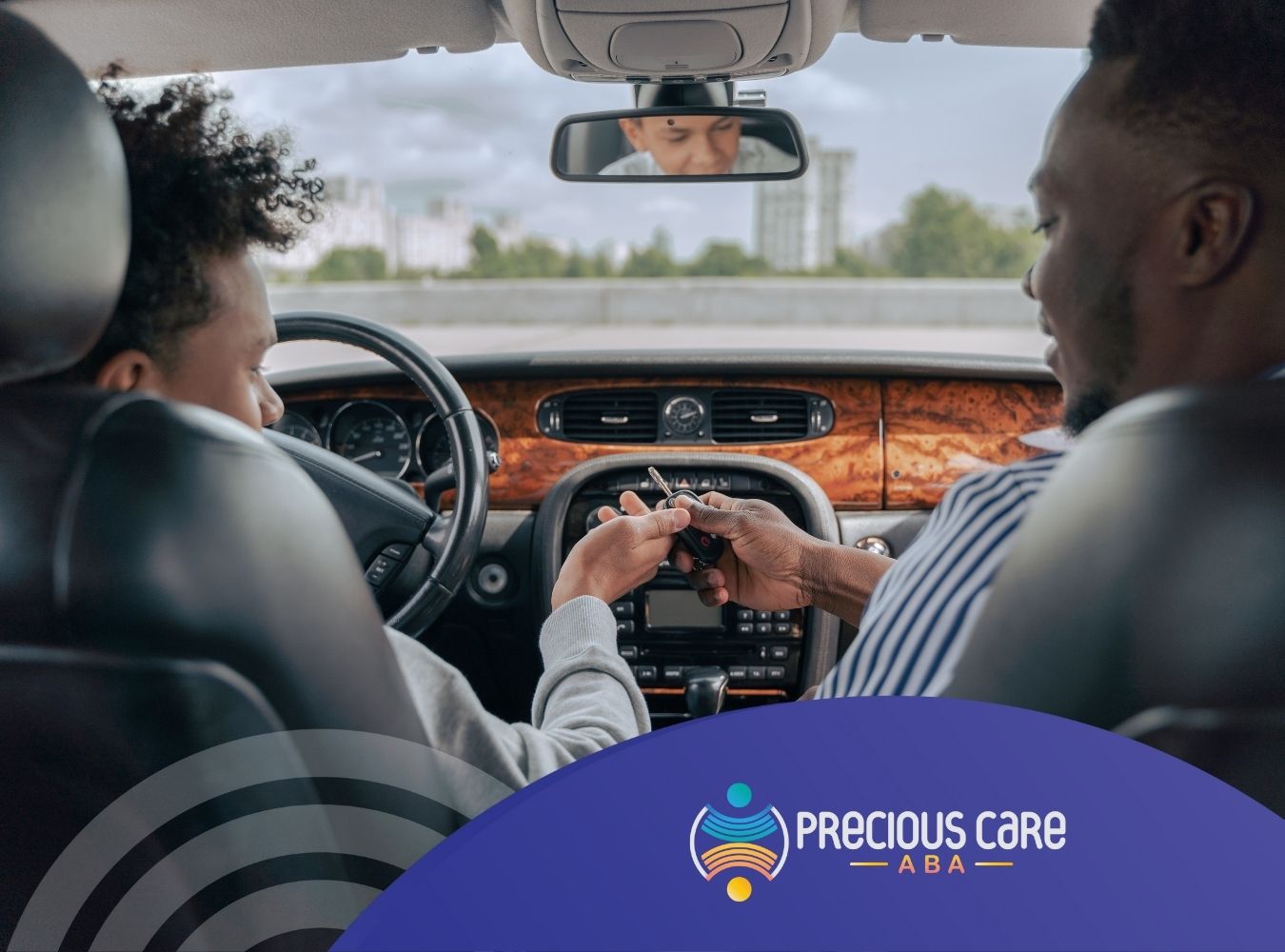 Two people sit in a car; one hands keys to the other, conveying a sense of trust. The dashboard is wooden.