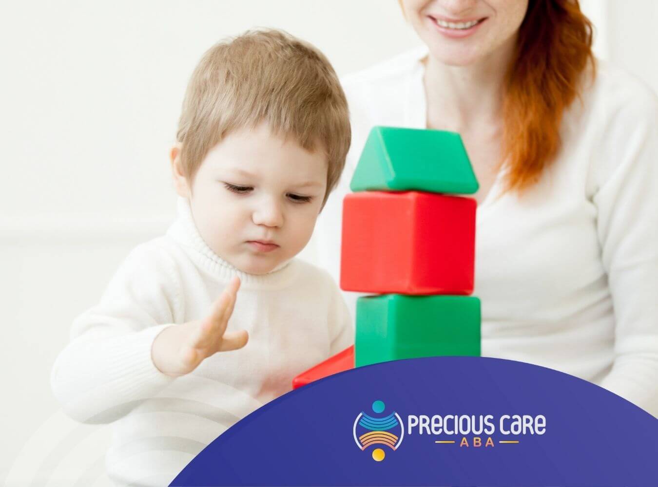 A child with autism stacking colorful blocks while an ABA therapist smiling in the background.
