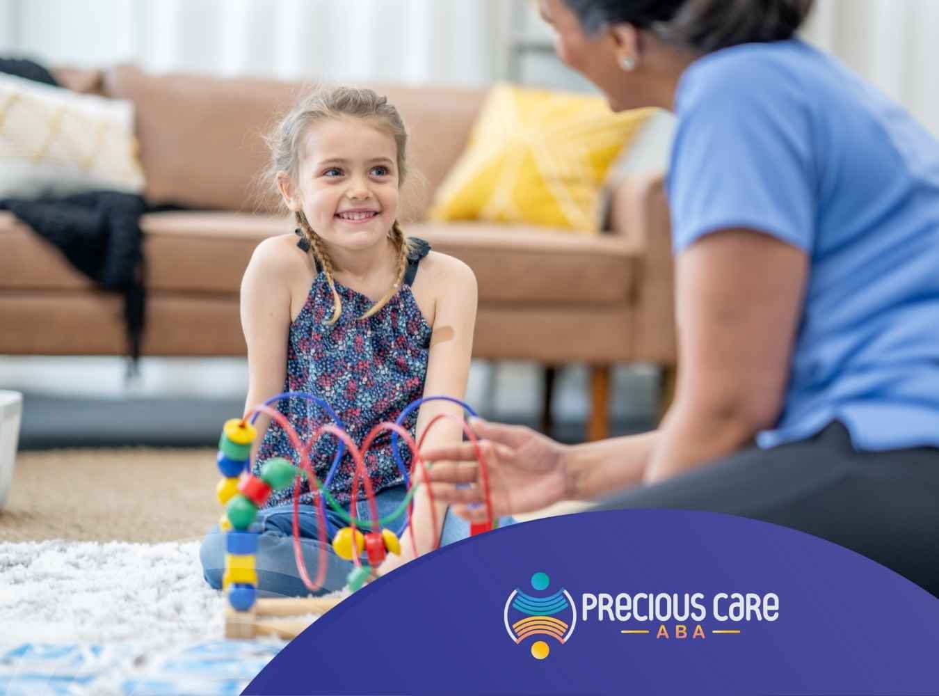 A young girl with braids smiles while playing with a colorful bead maze toy. An adult sits opposite her, fostering a joyful, supportive atmosphere in a cozy living room.