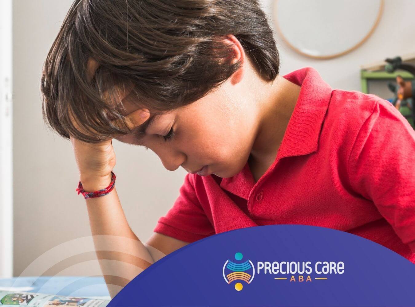 A boy with autism holding his head with a worried expression.