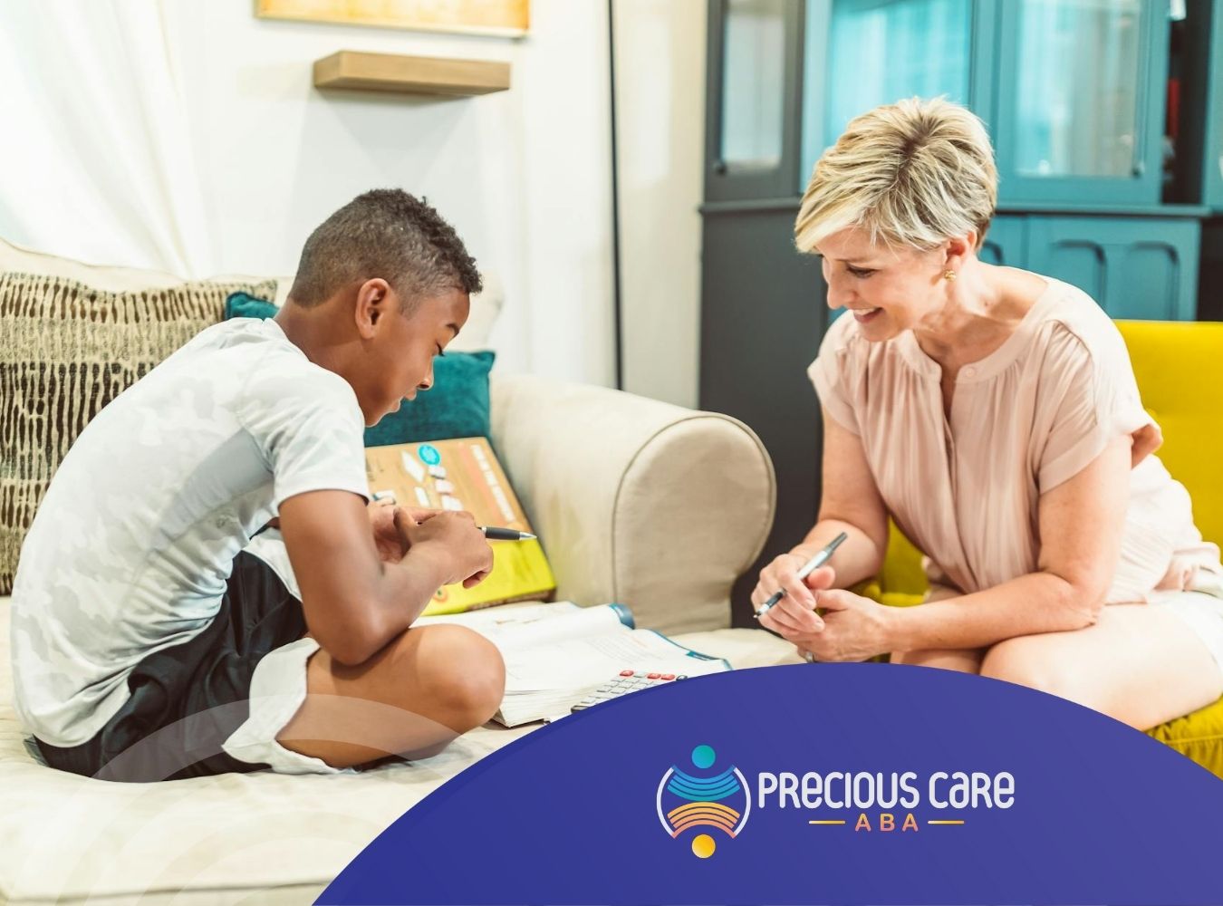 A BCBA helping boy with homework on the couch and observing him to create a personalized ABA therapy plan in CO.