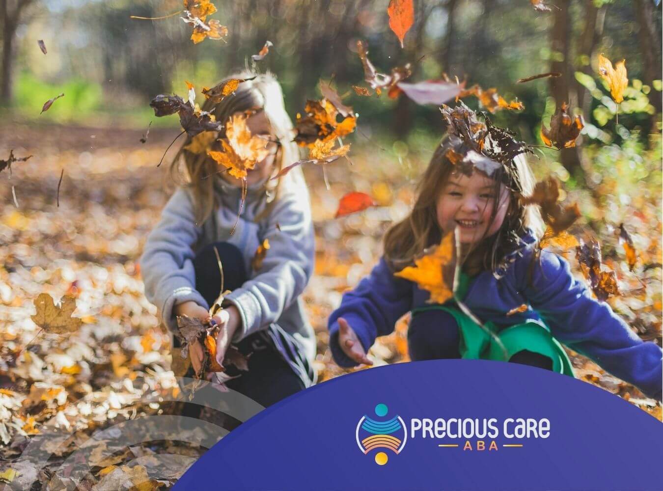 Two autistic girls laughing and throwing autumn leaves outdoors after their ABA Therapy in New Jersey