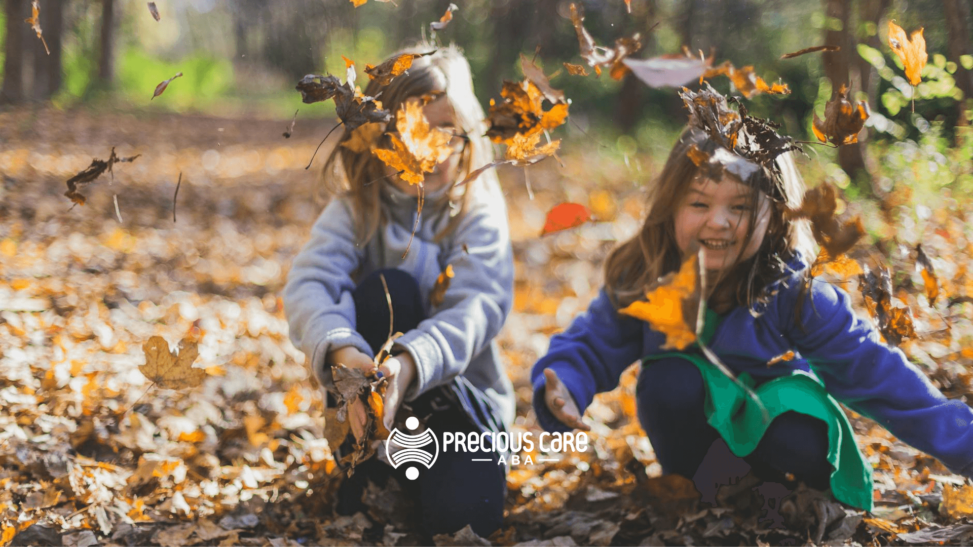 Two autistic girls laughing and throwing autumn leaves outdoors after their ABA Therapy in New Jersey