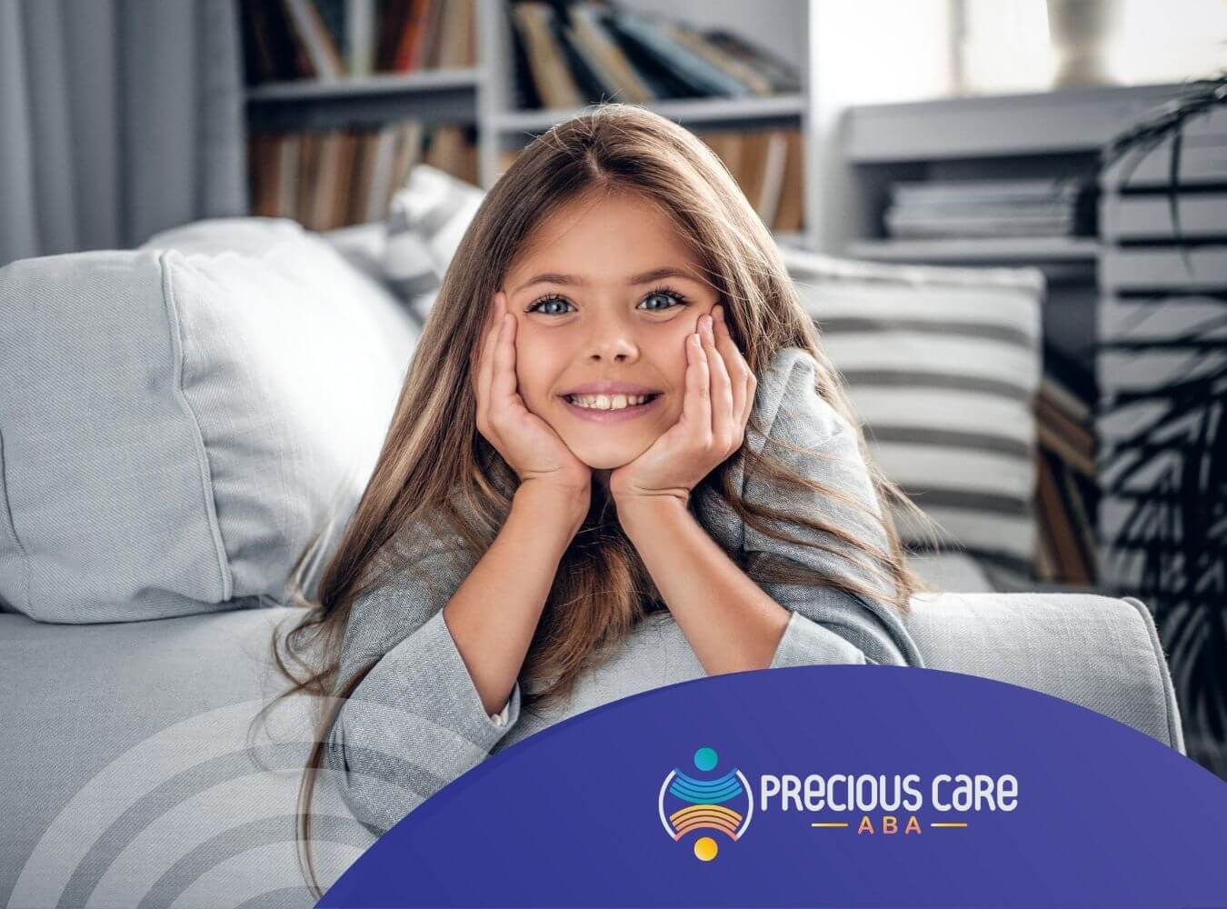 Smiling girl with autism resting her face on her hands while sitting on a sofa.
