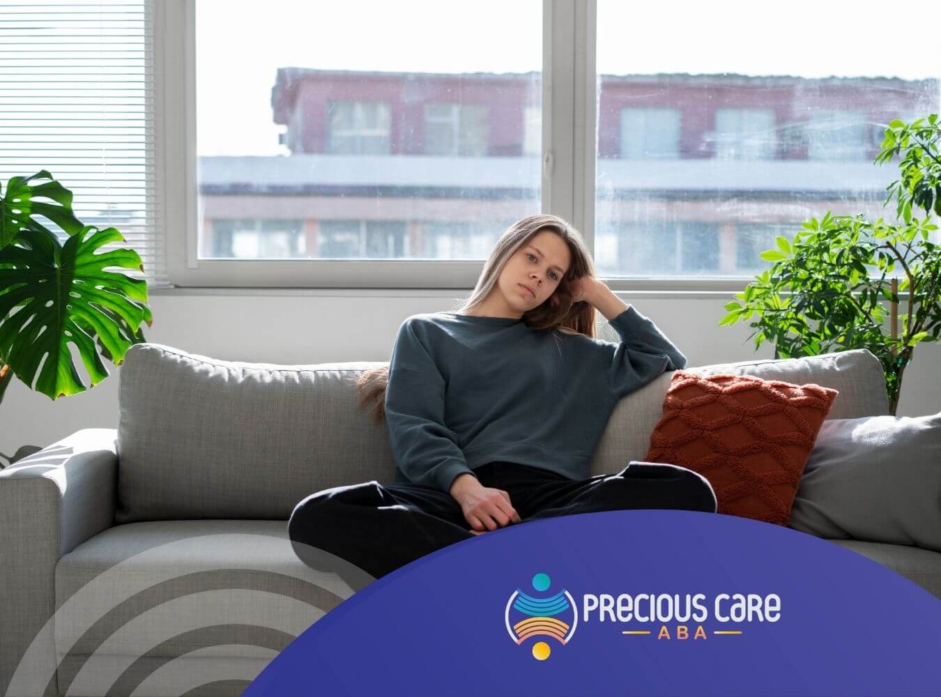Woman with autism sitting on couch, looking thoughtful.